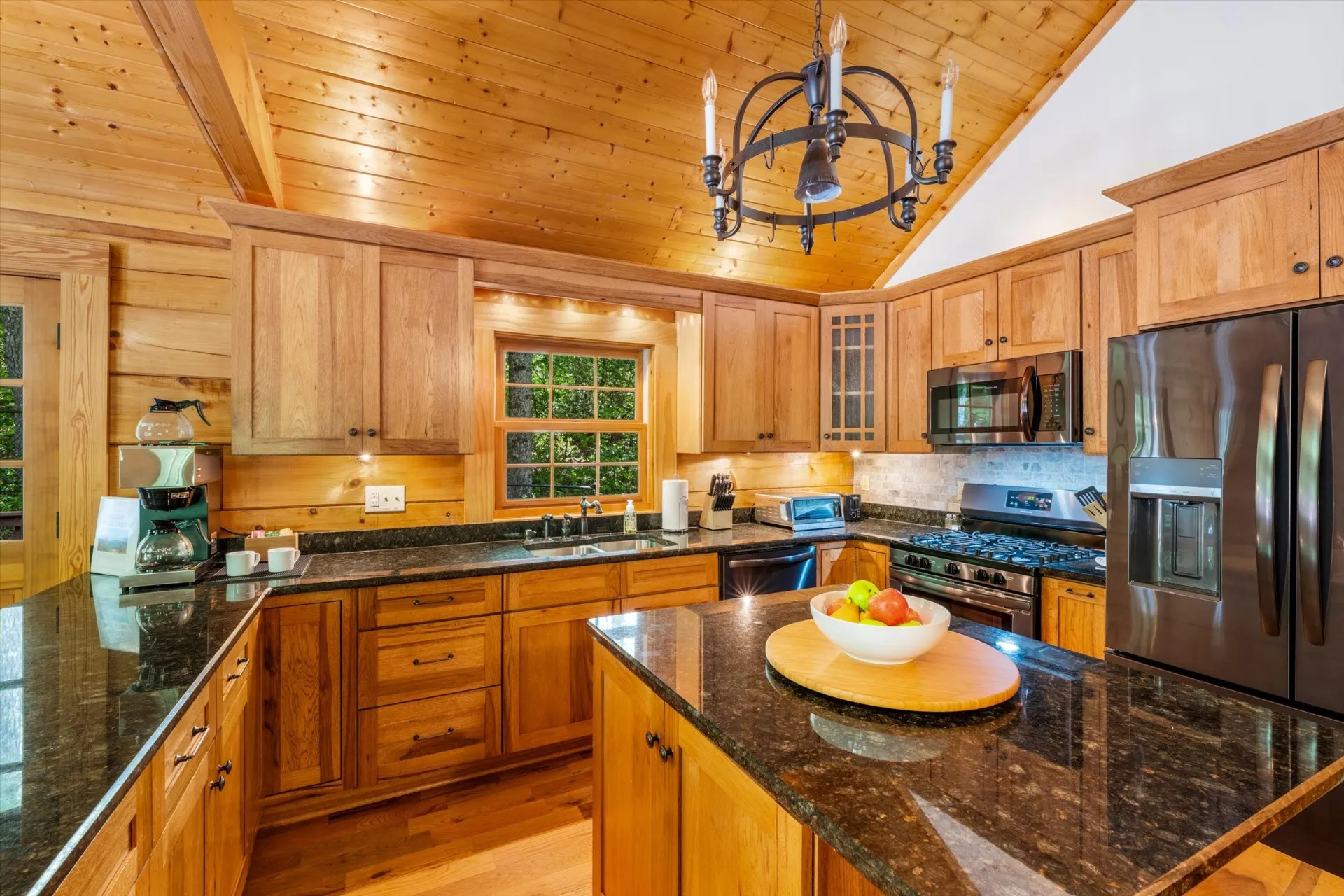 Fully equipped kitchen with granite counters, gas range, stainless appliances, Bunn dual-pot coffee maker, and a center island